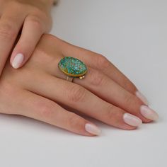 This stunning ring features vibrant blue-green turquoise, veined with the most intriguing golden inclusion patterns. Stone is wrapped in 22k gold and accented with a pair of sparkling diamonds set in 22k gold. Sterling silver back and 4mm hammered band. Stone measures approximately 1/2 inch x 3/4 inch. Matte finish. Sterling Silver Turquoise Ring In Yellow Gold, Handmade Yellow Gold Turquoise Ring, Oval Gold Turquoise Ring In Sterling Silver, Gold Oval Turquoise Ring In Sterling Silver, Unique Yellow Gold Turquoise Ring For Gift, Unique Gold Turquoise Ring With Gemstone, Gold Oval Turquoise Sterling Silver Ring, Unique Yellow Gold Oval Turquoise Ring, Sterling Silver Turquoise Ring With Yellow Gold Gemstone