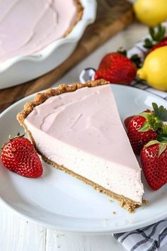 a slice of strawberry cream pie on a white plate with strawberries and lemons