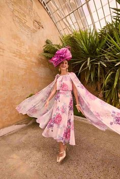 a woman in a pink dress and purple hat