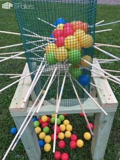 a basket full of balls sitting on top of a wooden bench next to sticks and tees