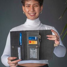 a woman holding an open wallet with credit cards in it