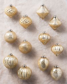 twelve shiny gold christmas ornaments on a white background