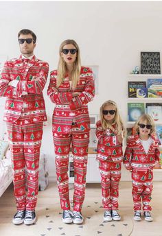 a man and woman in matching christmas pajamas standing next to their daughter, who is wearing sunglasses