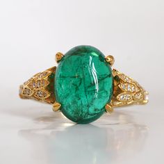 Read about our payment plans before proceeding.This is what dreams are made of. This emerald ring features an insanely gorgeous deep green natural cabochon emerald stone, embellished with 57 natural white diamonds with details like phoenix wings. A classy and sleek ring to treasure forever. Handcrafted in your choice of 14K yellow gold, rose gold, and white gold. The emerald shown is the exact same emerald you will receive. 14K solid gold Natural 12*9mm natural cabochon emerald. Approx. 2.8ct~. Luxury Oval Emerald Birthstone Ring, Fine Jewelry Emerald Oval Cabochon Ring, Fine Jewelry Emerald Ring With Oval Cabochon, Emerald Oval Cabochon Ring As A Gift, Yellow Gold Emerald Ring Oval Cabochon, Yellow Gold Emerald Ring With Oval Cabochon, Green Oval Cabochon Emerald Ring, Fine Jewelry Emerald Green Oval Cabochon Ring, Elegant Cabochon Emerald Ring