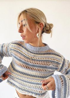 a woman wearing a sweater with crochet on it