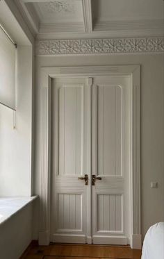 an empty room with two white doors and wood floors