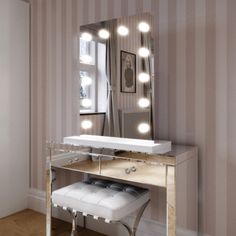 a dressing table with lights on it and a stool in front of the vanity mirror