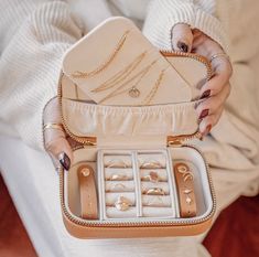 a woman holding an open purse filled with jewelry