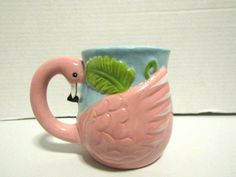 a pink flamingo mug with green leaves on it