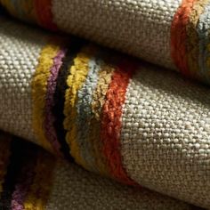 multicolored rugs are stacked on top of each other in this close up photo