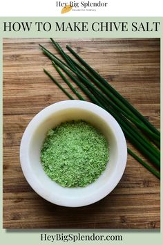 a white bowl filled with green powder next to two green onions on top of a wooden table