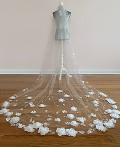 a dress on a mannequin is covered with white flowers and veiled over it