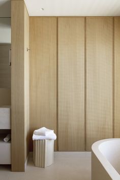 a bath room with a tub and a towel on the ground next to it's walls