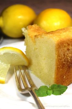 a piece of lemon pound cake on a plate with a fork and lemons in the background