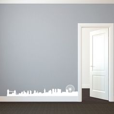 an open door in a room with a city skyline wall decal on the wall