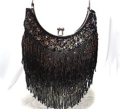 - Gorgeous black satin beaded fringe Deco style vintage evening bag...beautiful condition!- Beautiful gold and gunmetal bugle and seed bead long fringe design on both sides- Rhinestone and sequin border at top edge of silver framed pouch style bag- Twist top opening in  silver...frame scissors open- Handbag measures 6-1/2" wide X 6" center front length X 2"To see all of my Vintage Handbags click on this link....https://www.etsy.com/your/shops/TanglewoodTrims/tools/listings/section:21125977To see Rectangular Fringe Evening Bag For Party, Rectangular Evening Bag With Fringe, Elegant Evening Bags With Beaded Fringe, Glamorous Evening Bags With Fringe, Glamorous Evening Bags With Tassels, Evening Rectangular Bags With Beaded Fringe, Elegant Shoulder Bag With Beaded Fringe For Party, Elegant Evening Bag With Beaded Fringe, Rectangular Fringe Clutch For Evening