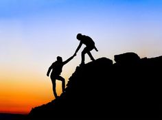 two people are helping each other climb up a mountain at sunset or sunrise with the sun setting in the background