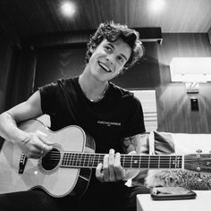 a young man is playing an acoustic guitar