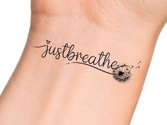 a tattoo that reads, just breathe on the wrist