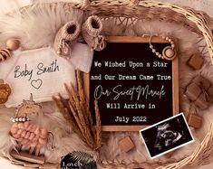 a basket filled with baby items on top of a white bed next to a sign