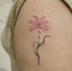 a woman's thigh with a pink flower tattoo on her left side ribcage