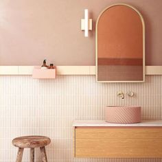 a bathroom with a stool, mirror and sink in the corner next to a counter