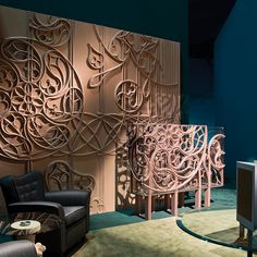 a living room filled with furniture next to a wall covered in intricately carved panels