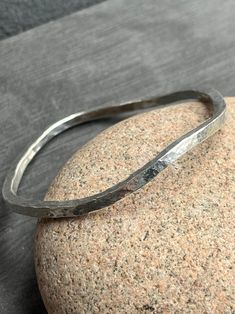 This silver wave bangle is made from hammered Sterling silver. The thickness of the square silver wire is 3mm wide. The shiny bangle fits a medium size wrist ( approximately 7cm in diameter). If you require a different size please don't hesitate to let me know at Checkout or message me. Hammered Sterling Silver Bangle Bracelet, Hand Forged Sterling Silver Bangle Bracelet, Modern Hammered Sterling Silver Bangle, Minimalist Hammered Silver Bangle, Minimalist Silver Hammered Bangle, Chunky Silver Bracelet, Hammered Bangles, Bangle Silver, Hammered Sterling Silver