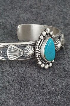 This Kingman turquoise and sterling silver bracelet was made by Navajo silversmith Michael Calladitto. The inside is signed MC and stamped Sterling.Size: 5 3/4" (will fit up to a 7 1/8" wrist)Gap: 1 3/8"Width: 1 1/8"Cuff Width: 1/2"Free shipping on all orders! We ship with USPS and always include tracking. All orders ship within a day of payment.Returns are accepted up to 30 days after you receive your order. Just send us a message. Our shop offers cash back or store credit. The item must be ret Adjustable Southwestern Sterling Silver Bracelet With Turquoise, Adjustable Southwestern Turquoise Sterling Silver Bracelet, Adjustable Turquoise Sterling Silver Bracelet In Southwestern Style, Stamped Turquoise Sterling Silver Bracelet, Stamped Sterling Silver Bracelet In Turquoise, Southwestern Style Stamped Turquoise Bracelets, Sterling Silver Turquoise Stamped Bracelet, Southwestern Etched Turquoise Jewelry, Southwestern Style Turquoise Stamped Bracelets