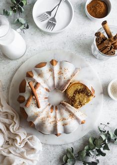 a bundt cake on a plate with cinnamon sprinkles and spices around it