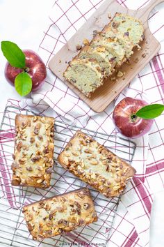 apples and cinnamon bread on a cooling rack next to an apple slice, two pieces of cake