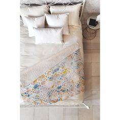 an overhead view of a bed with white pillows and blankets on top of it,