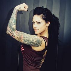 a woman with tattoos on her arm posing for the camera