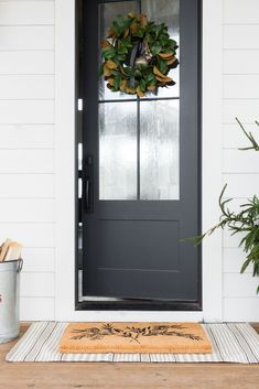 a black front door with a wreath on it