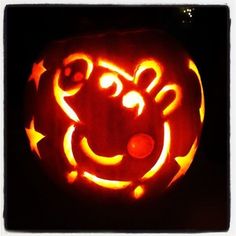 a pumpkin carved to look like a smiley face with stars and circles on it's side