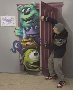 a young boy is painting a mural on the side of a wall with monsters and aliens