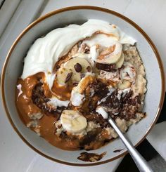 a bowl filled with oatmeal and bananas on top of a white table