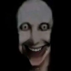 a creepy looking person with long hair and big eyes is smiling at the camera while wearing a white mask