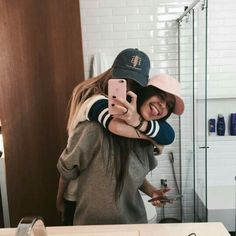 two people taking a selfie in a bathroom mirror with their arms around each other