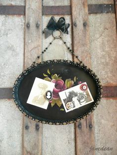 an old wooden door with some pictures hanging on the side and a bow attached to it