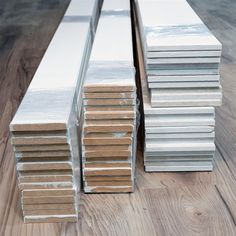 several stacks of metal sheets on a wooden floor