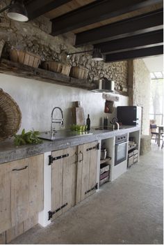 a kitchen with wooden cabinets and stone walls