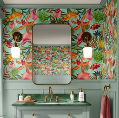 a bathroom with floral wallpaper and green vanity