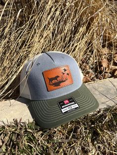 These leather patch Richardson 112FP hats are a great way to flaunt your style and look sleek at the same time. Patches made from 100% leather and engraved with a crisp design and hand stitched on our most popular style of hat. Your friends are going to be jealous! To submit custom logo- Please email brent@lumberjackdesignco.com with the Vector logo, it will be labeled .eps, .ai, .pdf (Please do not submit a jpg in this format as this will need redrawn and art charges will apply for hourly rates!) Multiple hat colors available, Bulk pricing available (see below) custom shape patches available upon request. SIZE OF PATCH HEIGHT WILL VARY DEPENDING ON CUSTOMER LOGO If a hat color is not listed please message us and we can order in a custom color if needed. Rugged Outdoor Hat With Leather Patch, Leather Hunting Hat With Flat Brim, Leather Hats For Hunting With Flat Brim, Trucker Hat With Leather Patch And Short Brim, Western Hats With Leather Patch For Outdoor, Country Style Flat Bill Hats With Leather Patch, Country Style Hat With Leather Patch And Flat Bill, Western Outdoor Hat With Leather Patch, Country Style Hat With Leather Patch