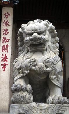 a stone lion statue with chinese writing on it