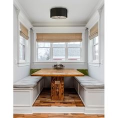 a kitchen with a table, bench and window seat in it's center area