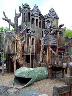 an outdoor play area for children with wooden structures and climbing equipment, including a tree house