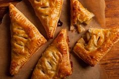 four pieces of pie sitting on top of a piece of wax paper