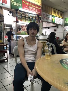 a man sitting at a table with a beer in front of him