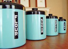 a group of blue canisters sitting on top of a wooden table